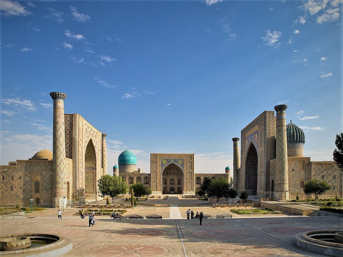 Registan Square in Samarkand, its turquoise tiled madrasah facades rising under a clear sky